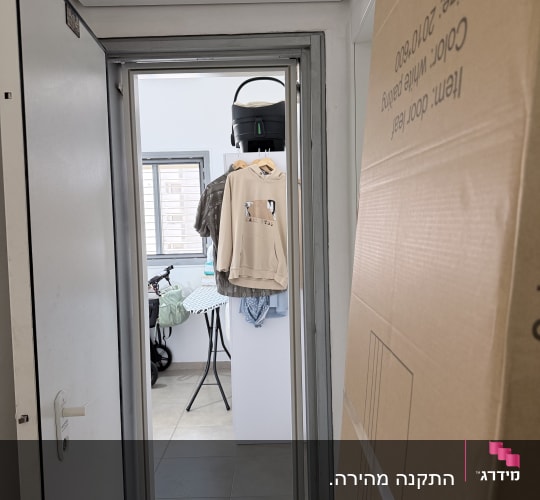 התקנת דלת פנים לבנה לצד אריזת הקרטון של כנף הדלת